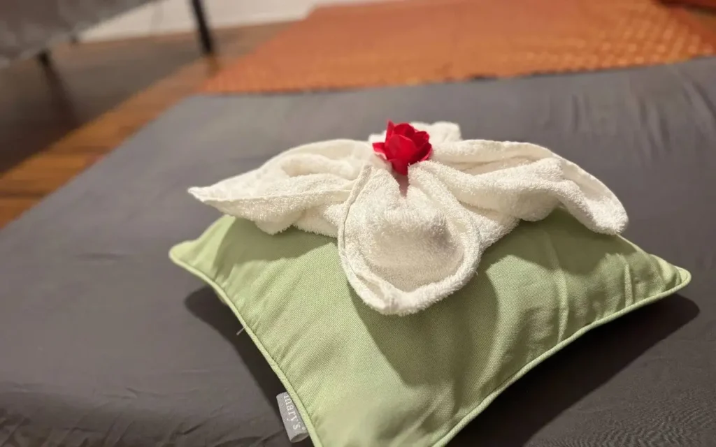 kleiner Polster mit Handtuch zu Deko geformt plus kleine rote Blume